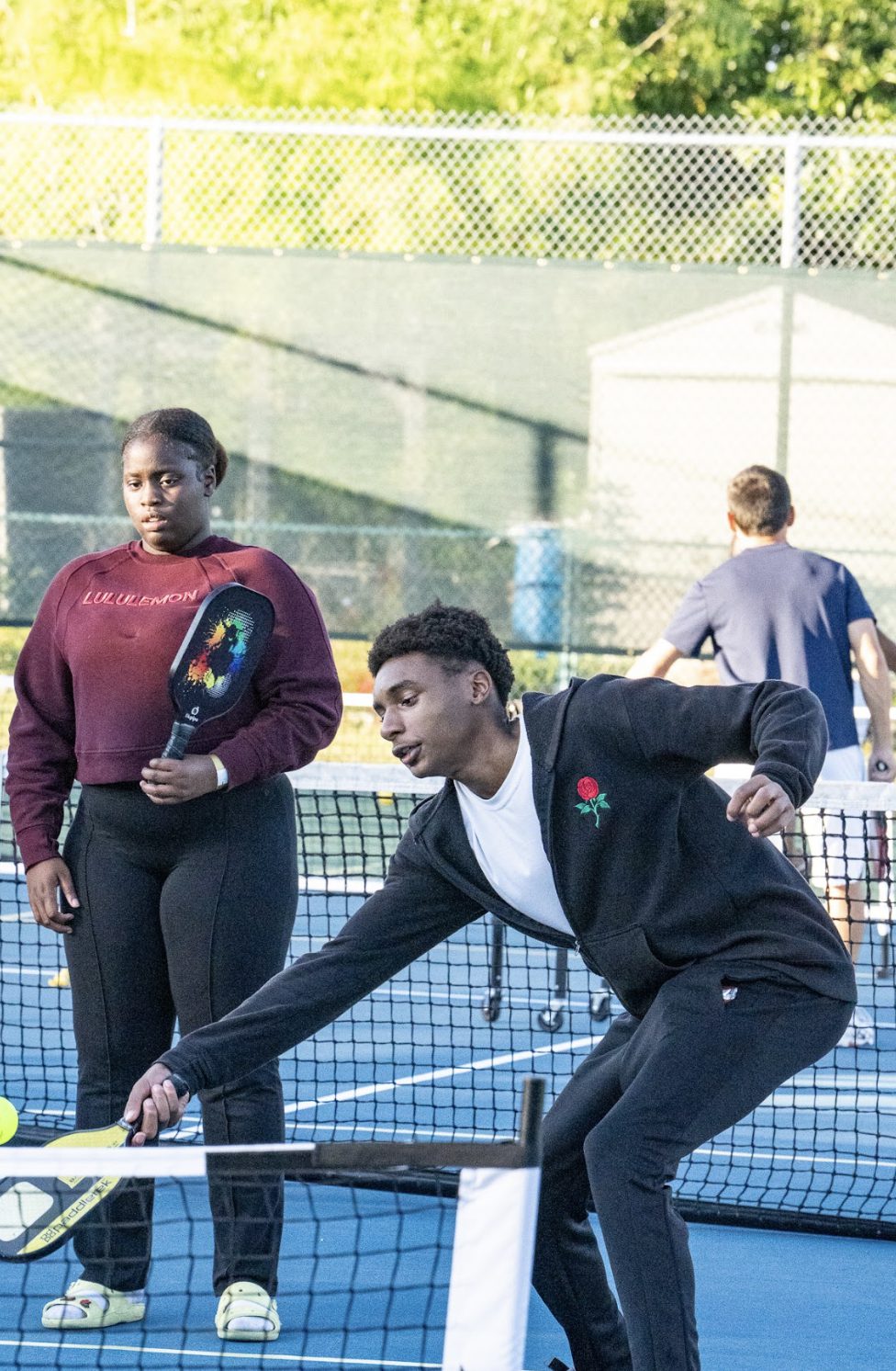 A player crouched low to return a ball near the net.