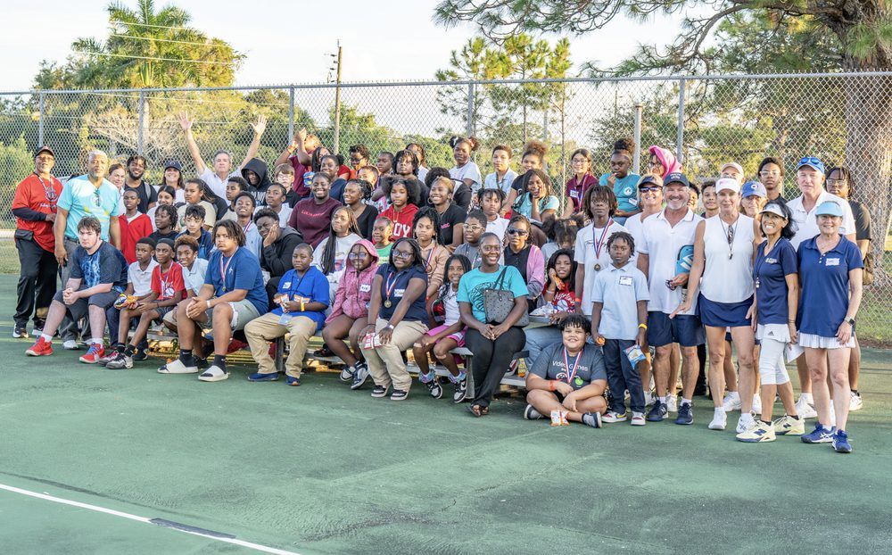 The full group of campers, coaches and volunteers posed together on court.